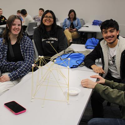 students gather around a table during a class